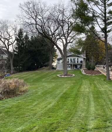 lakeside-hardscape-work-in-progress Lakefront hardscape work in progress alongside freshly mowed, striped lawn.